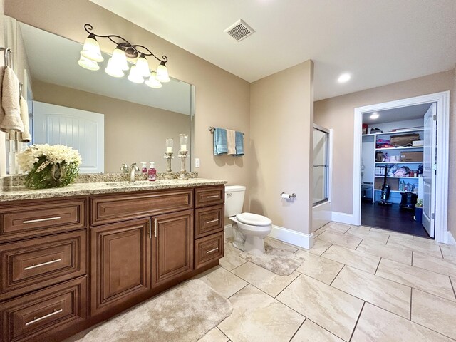 bathroom with walk in shower, tile patterned floors, vanity, and toilet