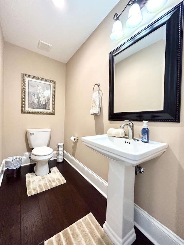 bathroom with wood-type flooring and toilet