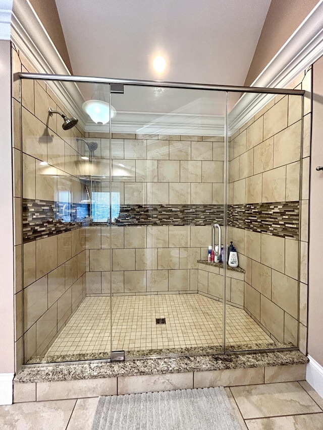 bathroom featuring ornamental molding, a shower with shower door, and vaulted ceiling