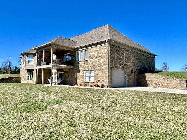 rear view of house with a balcony, a garage, and a yard