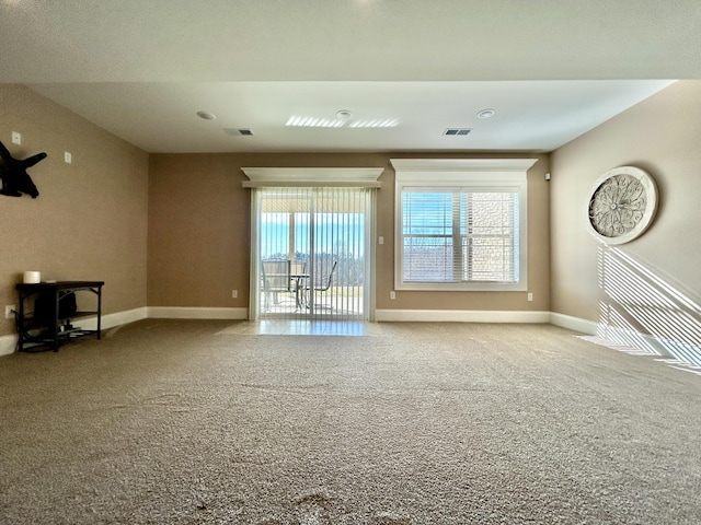 unfurnished living room featuring plenty of natural light and light carpet