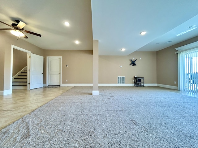 unfurnished living room with light colored carpet and ceiling fan