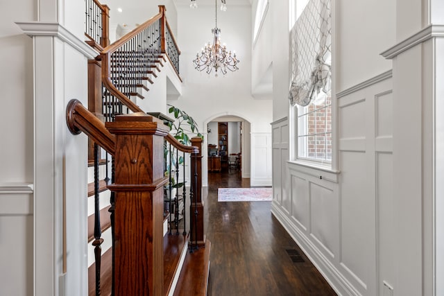 stairs featuring a high ceiling and an inviting chandelier