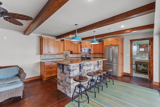 kitchen featuring light stone counters, sink, decorative light fixtures, and appliances with stainless steel finishes