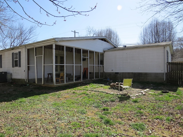 back of house featuring central AC unit, a yard, and a sunroom