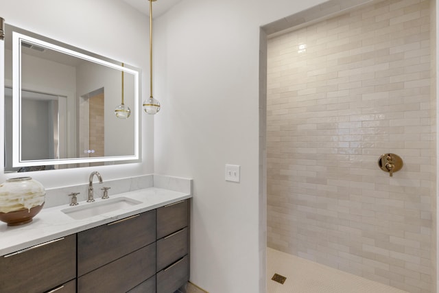 bathroom with vanity and a tile shower