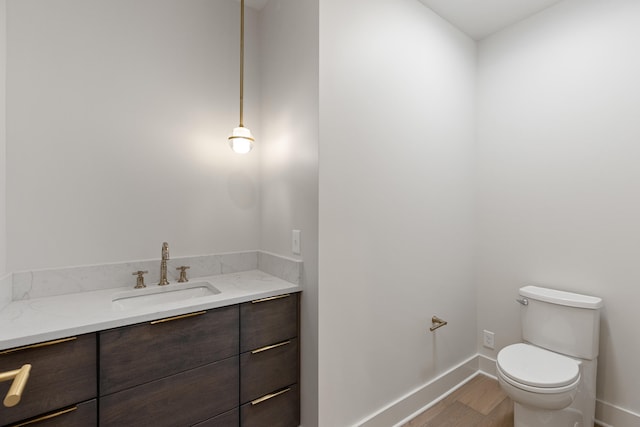 bathroom featuring vanity, toilet, and hardwood / wood-style flooring