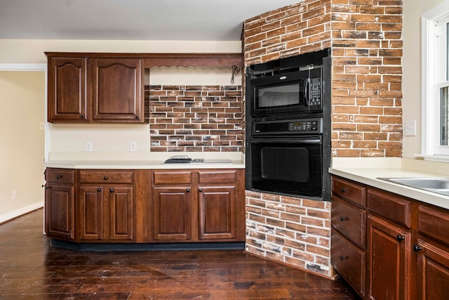 kitchen with dark hardwood / wood-style floors and black appliances