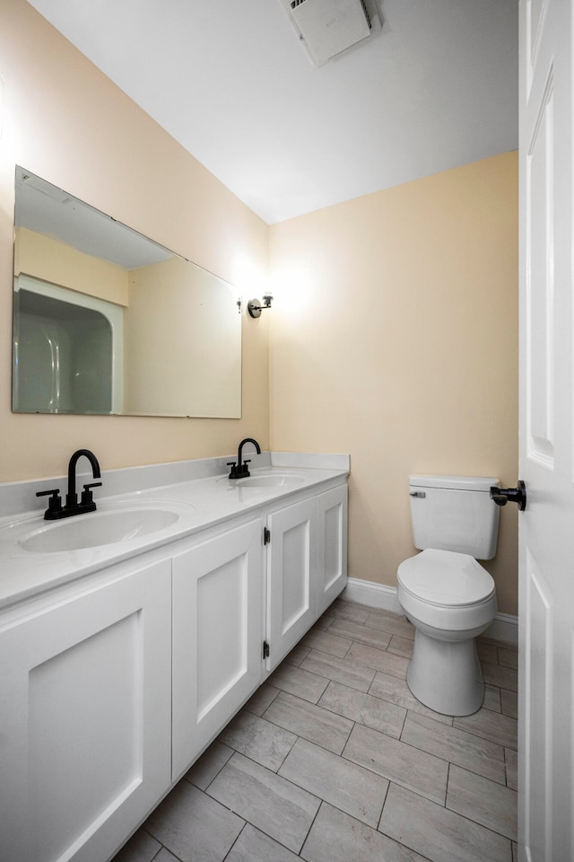 bathroom featuring tile flooring, toilet, and dual bowl vanity