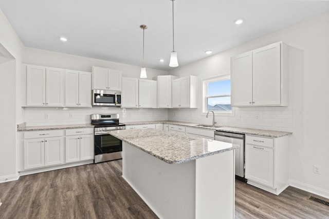 kitchen featuring white cabinets, a kitchen island, and appliances with stainless steel finishes