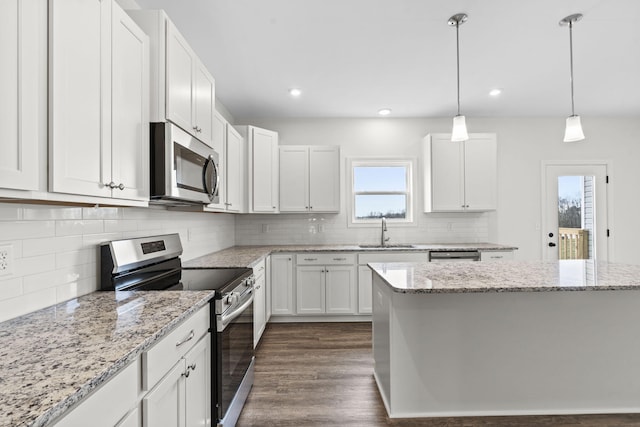 kitchen featuring white cabinets, a healthy amount of sunlight, dark hardwood / wood-style floors, and appliances with stainless steel finishes