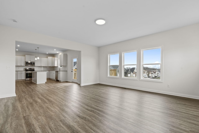 unfurnished living room with dark wood-type flooring