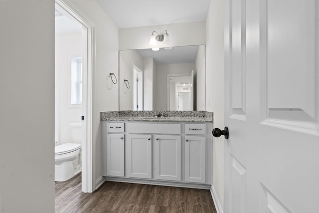 bathroom with hardwood / wood-style floors, vanity, and toilet