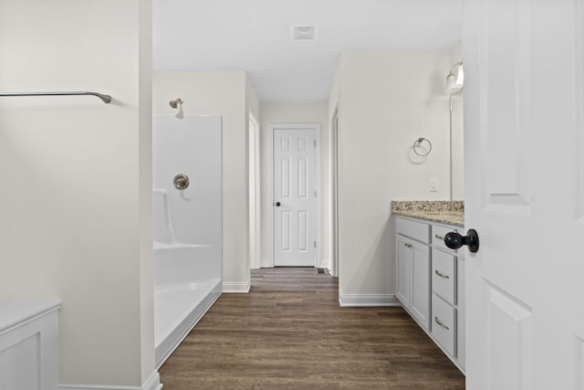 bathroom featuring vanity, wood-type flooring, and walk in shower