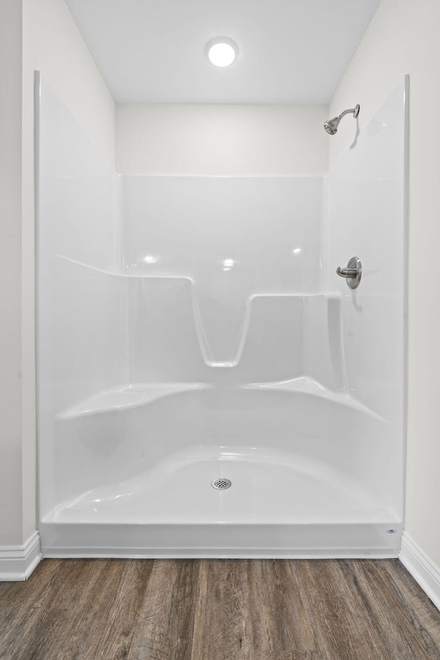 bathroom with wood-type flooring and walk in shower