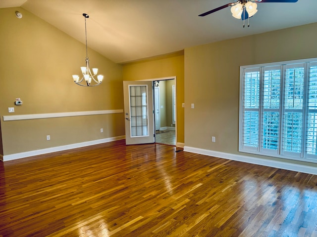 unfurnished room featuring ceiling fan with notable chandelier, dark hardwood / wood-style flooring, a wealth of natural light, and lofted ceiling