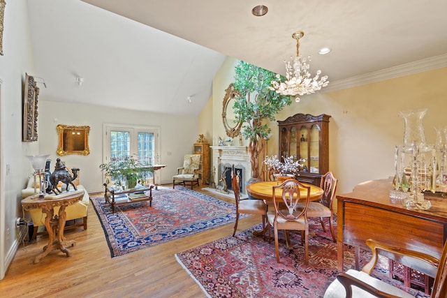 dining room with high vaulted ceiling, an inviting chandelier, and light hardwood / wood-style floors