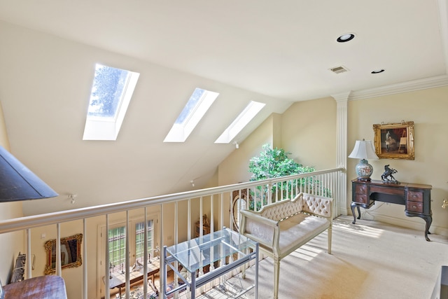 interior space with carpet, ornamental molding, and lofted ceiling with skylight