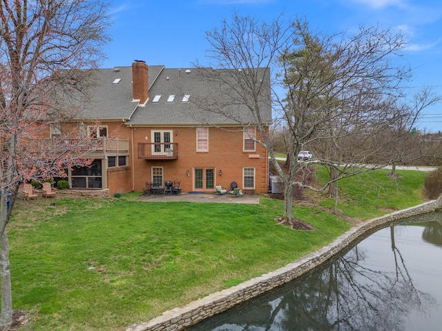 rear view of property featuring a patio area, french doors, and a lawn