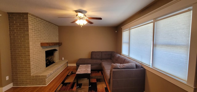 unfurnished living room with ceiling fan, a fireplace, and wood-type flooring