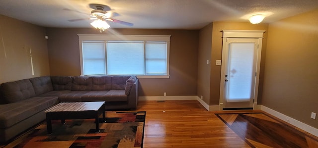 living room with ceiling fan, wood-type flooring, and a textured ceiling