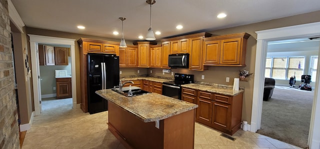 kitchen featuring pendant lighting, sink, black appliances, an island with sink, and light colored carpet