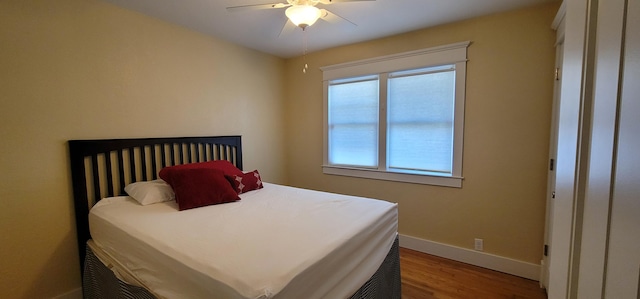 bedroom featuring multiple windows, ceiling fan, and light hardwood / wood-style flooring