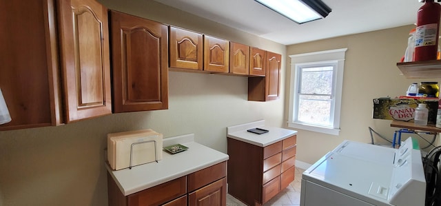 laundry room with cabinets, washing machine and dryer, and light tile patterned flooring