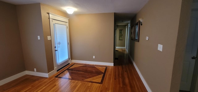 foyer entrance featuring wood-type flooring and a textured ceiling