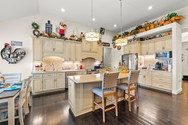 kitchen with pendant lighting, stainless steel appliances, a kitchen island, dark wood-type flooring, and backsplash