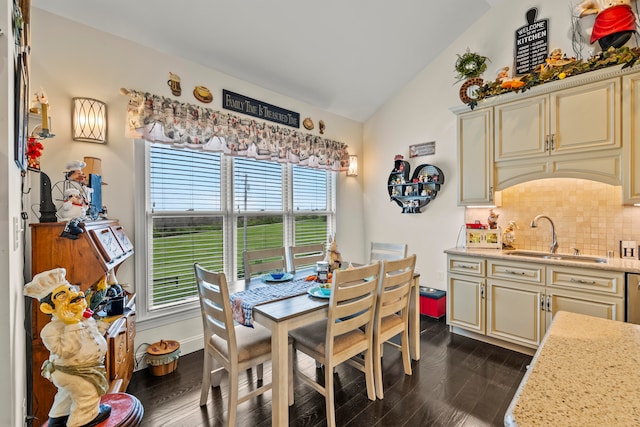 dining space with dark hardwood / wood-style flooring, sink, and vaulted ceiling