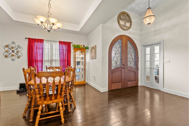 entryway featuring a notable chandelier, dark wood-type flooring, a healthy amount of sunlight, and a tray ceiling