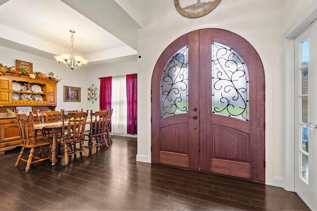 foyer entrance featuring a notable chandelier, dark hardwood / wood-style floors, and french doors