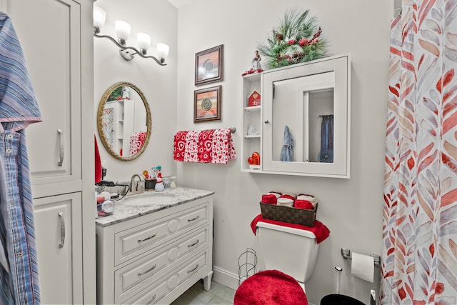 bathroom featuring tile flooring, toilet, and vanity