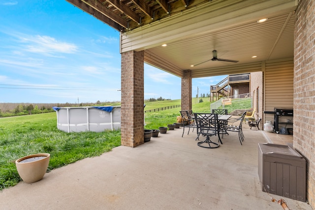 view of patio featuring grilling area, a covered pool, and ceiling fan