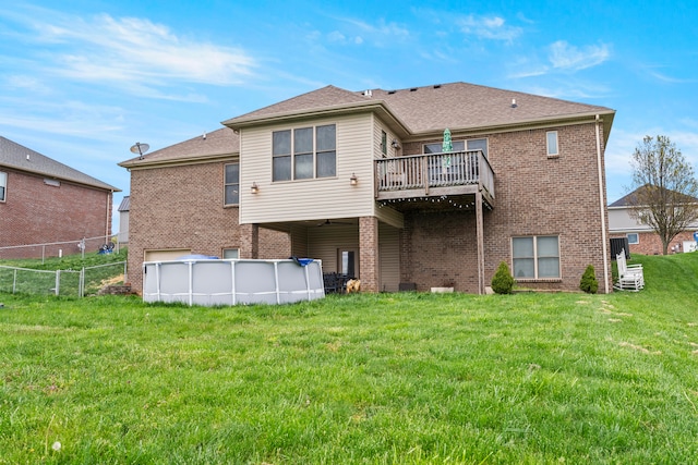 rear view of house with a swimming pool side deck and a lawn