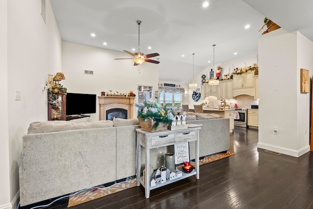 living room featuring ceiling fan, a towering ceiling, and dark hardwood / wood-style flooring