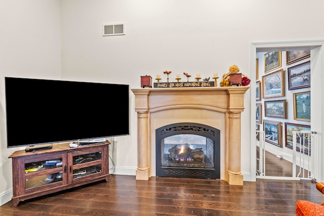 living room with dark hardwood / wood-style flooring and a multi sided fireplace