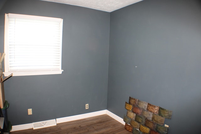 spare room with dark hardwood / wood-style flooring