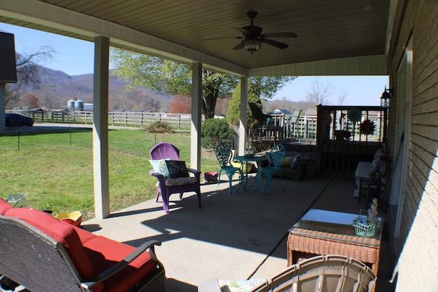 view of patio featuring an outdoor hangout area, a mountain view, and ceiling fan