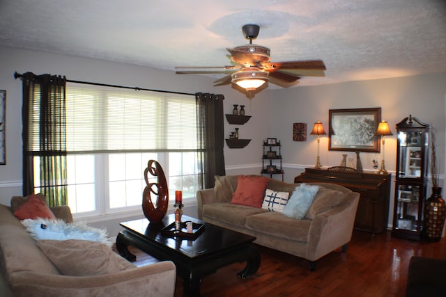 living room with a textured ceiling, ceiling fan, and dark hardwood / wood-style flooring