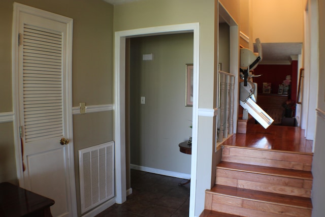 staircase with dark tile floors