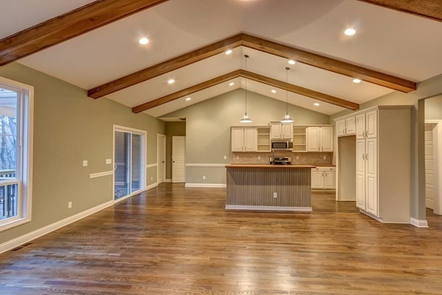 unfurnished living room with a wealth of natural light, beam ceiling, and hardwood / wood-style floors