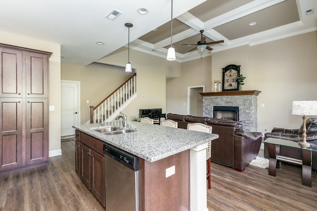 kitchen featuring dark hardwood / wood-style floors, a fireplace, sink, and dishwasher