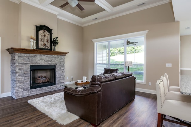 living room with dark wood-type flooring, ceiling fan, coffered ceiling, a fireplace, and crown molding