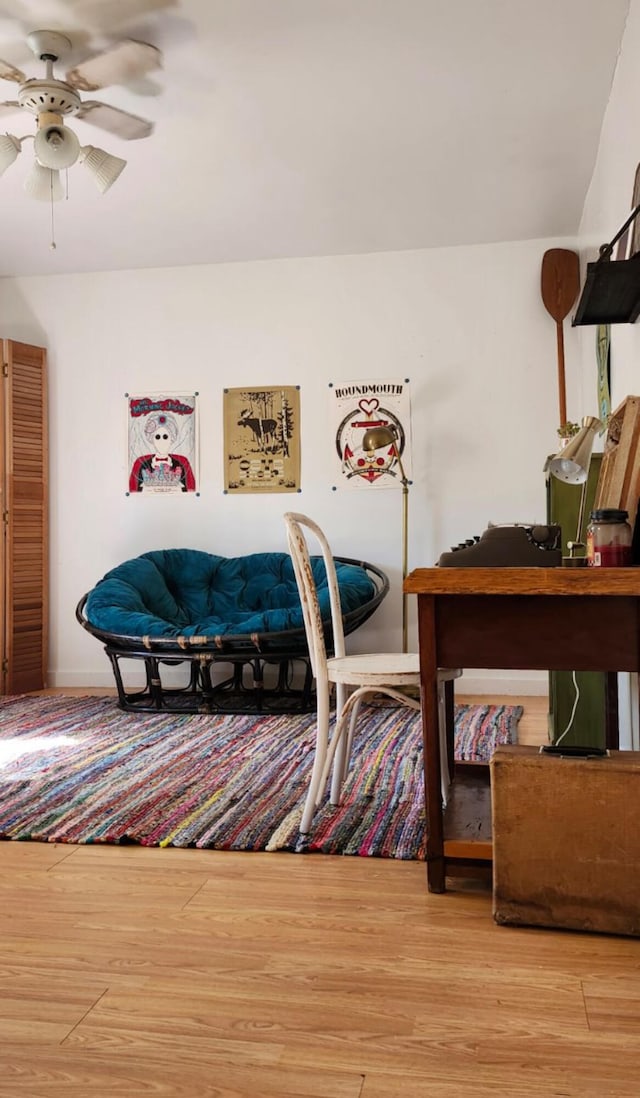 sitting room with a ceiling fan and wood finished floors