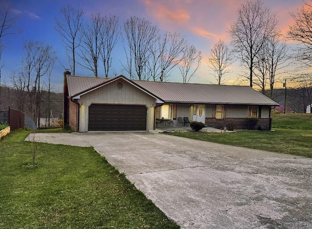 ranch-style home featuring a lawn and a garage