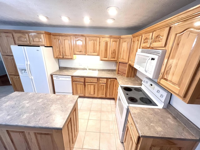 kitchen with white appliances, a textured ceiling, sink, light tile patterned floors, and a center island