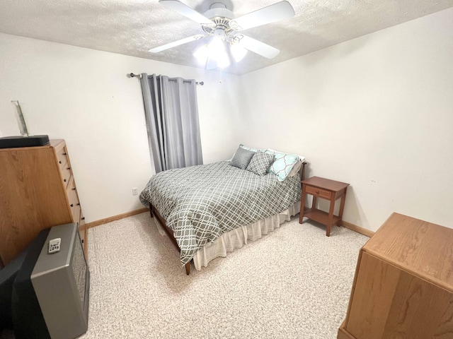 carpeted bedroom featuring ceiling fan and a textured ceiling