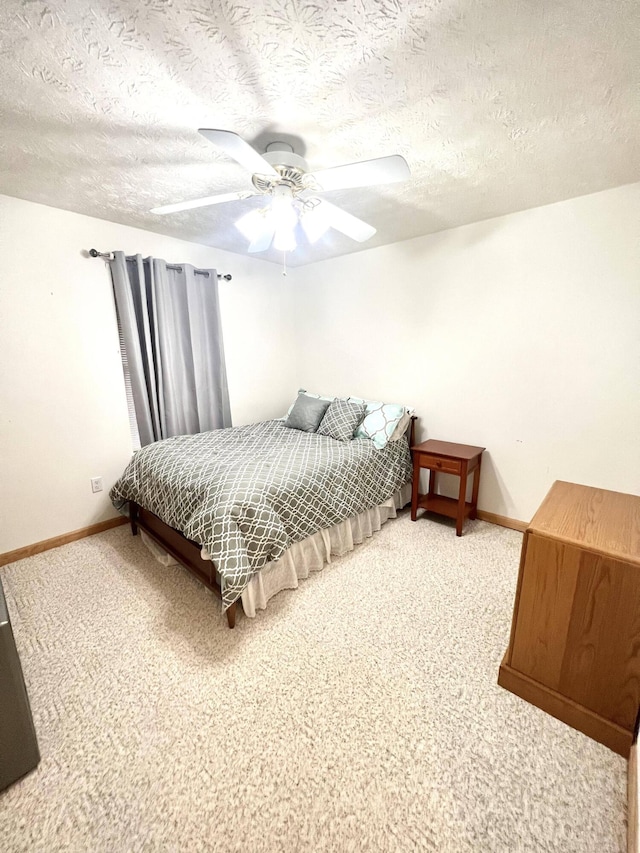 bedroom featuring ceiling fan, carpet, and a textured ceiling